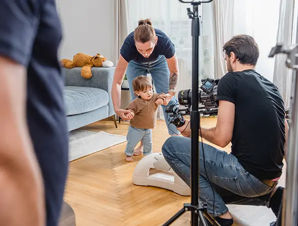 Kameramann filmt kleinen Jungen bei ersten Gehversuchen