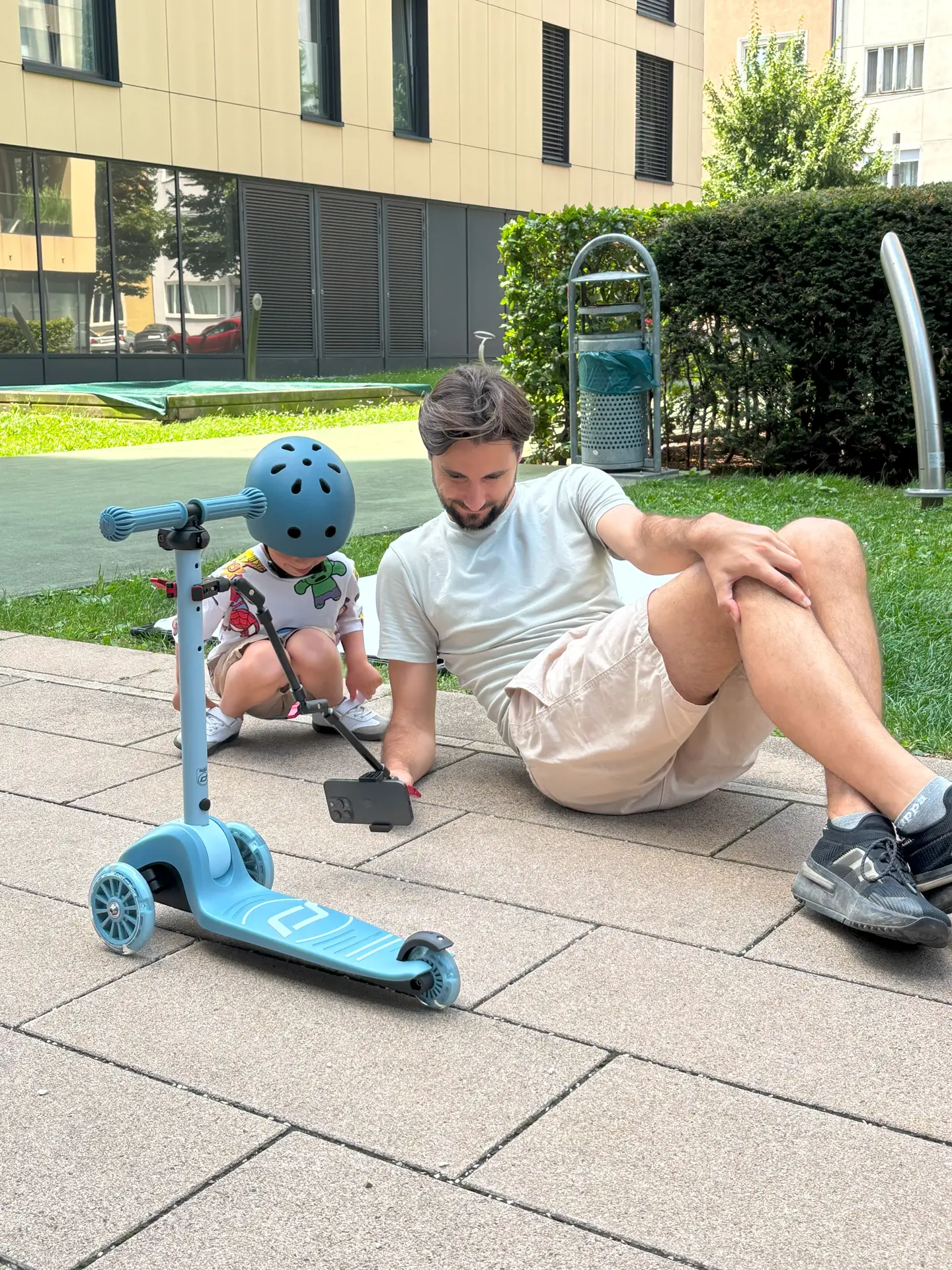 The boy and the cameraman are sitting on the floor watching video footage they have shot.
