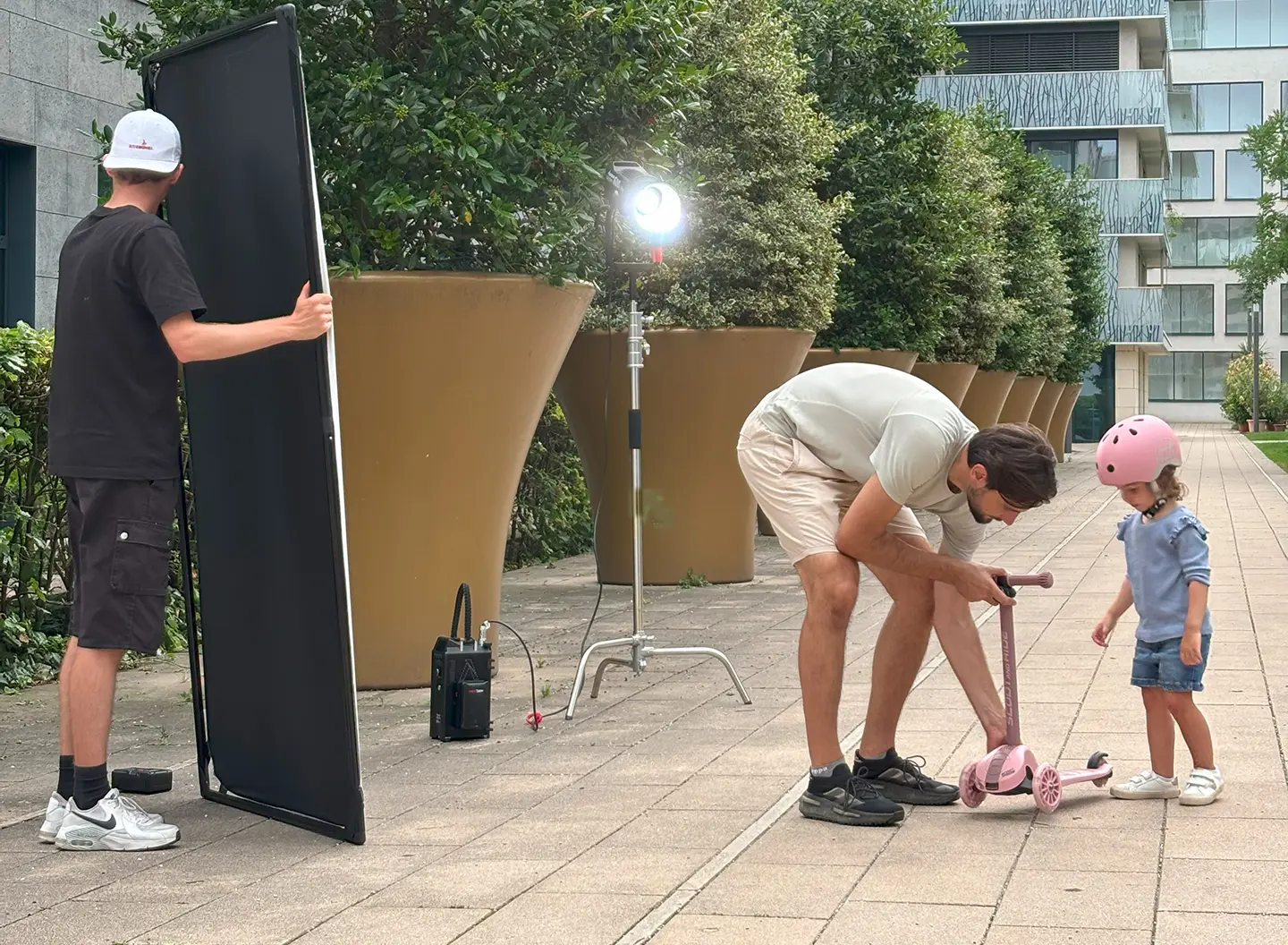Cameraman positions scooter, girl stands next to him and watches him